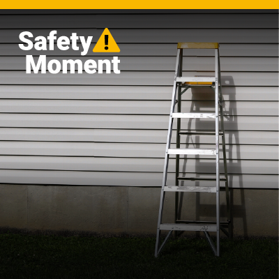 A ladder leans against a home with white siding