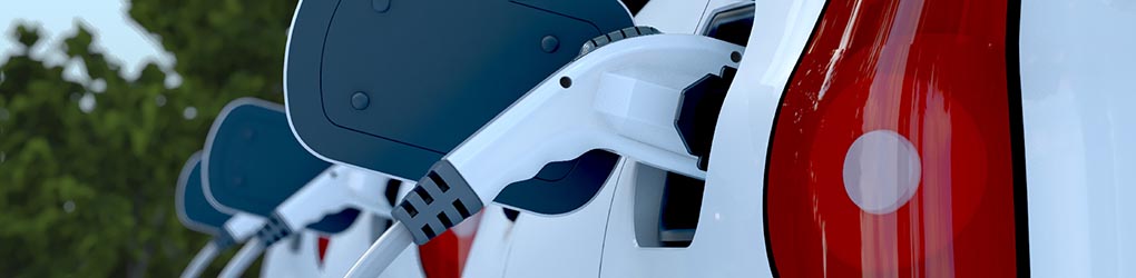 Row of electric vehicles plugged into charger